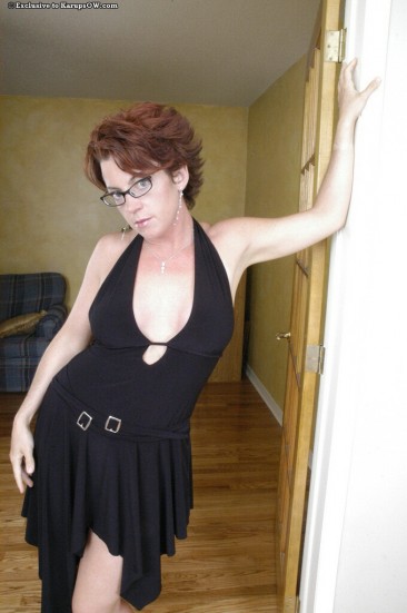 Spectacled big titted milf Holly Goes pulls off her black dress and pink panties