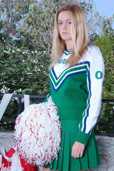 Fair haired Kira Beckam in green and white cheerleader uniform gets her shaved snatch out