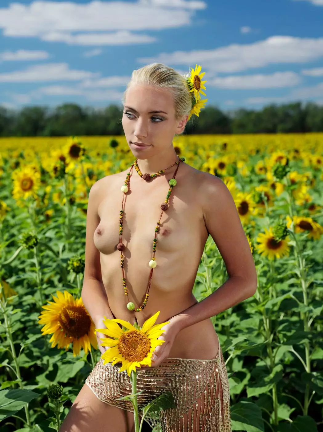 Charming blonde babe Adele B is naked in the middle of the sun flower field