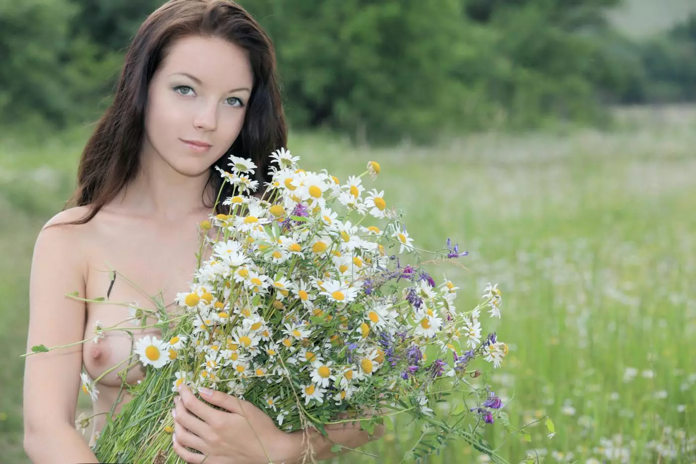 Brunette teen Diana H is in the meadow trying to cover nudity with flowers