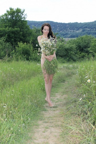 Brunette teen Diana H is in the meadow trying to cover nudity with flowers