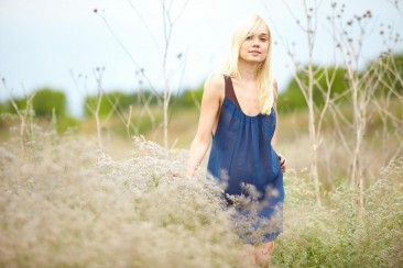 Blonde girl Aljena A takes off her dress and fools around in the blossoming meadow