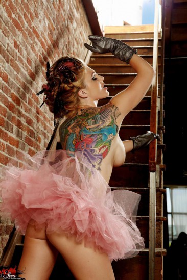 Tattooed redhead with big boobs and long legs Jesse Capelli poses on the stairs