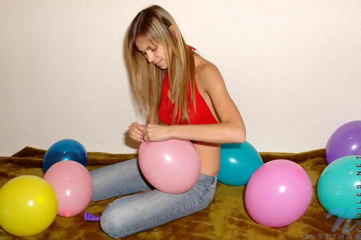 With her long blonde hair Katrina Nubiles blows up balloons and shows her teen side with cuteness. 