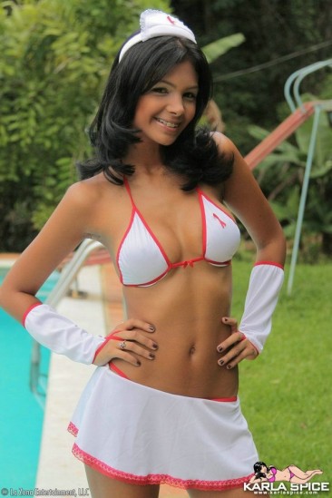 Swarthy latina Karla Spice in white uniform and bikini teasingly poses by the pool