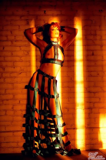 Redhead Justine Joli in amazing dress made of leather belts poses in the empty room