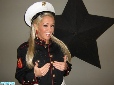 Smiling tanned blonde Foxy Jacky in uniform shows her smoothest pussy and round tits
