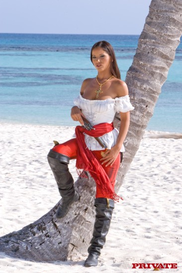 Perfect bodied busty pirate babe Angel Dark strips and poses naked on exotic white sand beach