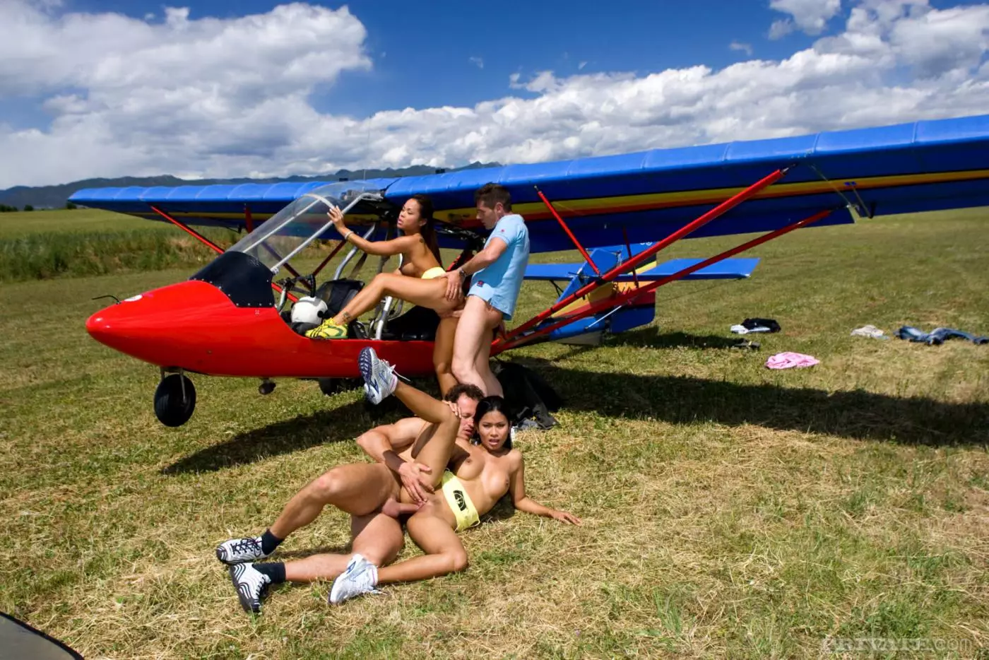 Asian girls Priva and Jade Sin get fucked by two guys in the field beside the plane